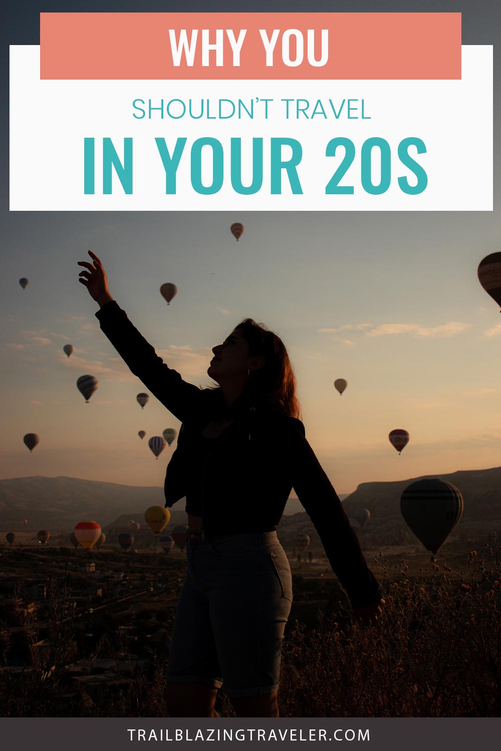 Girl extending her right hand upwards while hot air balloons are on the sky far away - Why You Shouldn’t Travel In Your 20s?